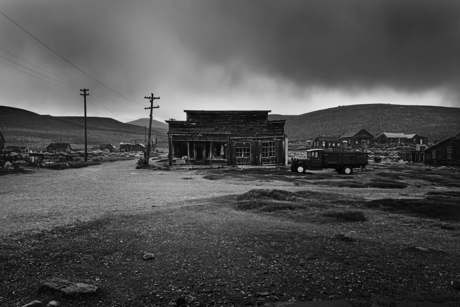 Old building exterior with stormy sky and truck in Bodi, California ghost town