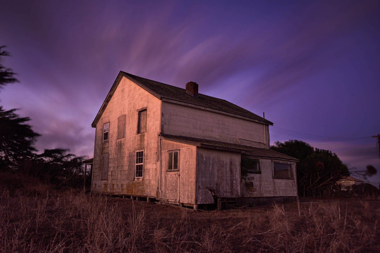 Old abandoned house at twilight with streaked clouds and D-Ranch, Point Reyes, California
