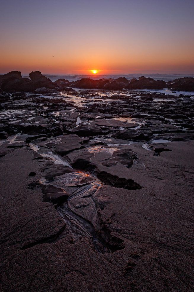 Rocky Pacific beach with sunset