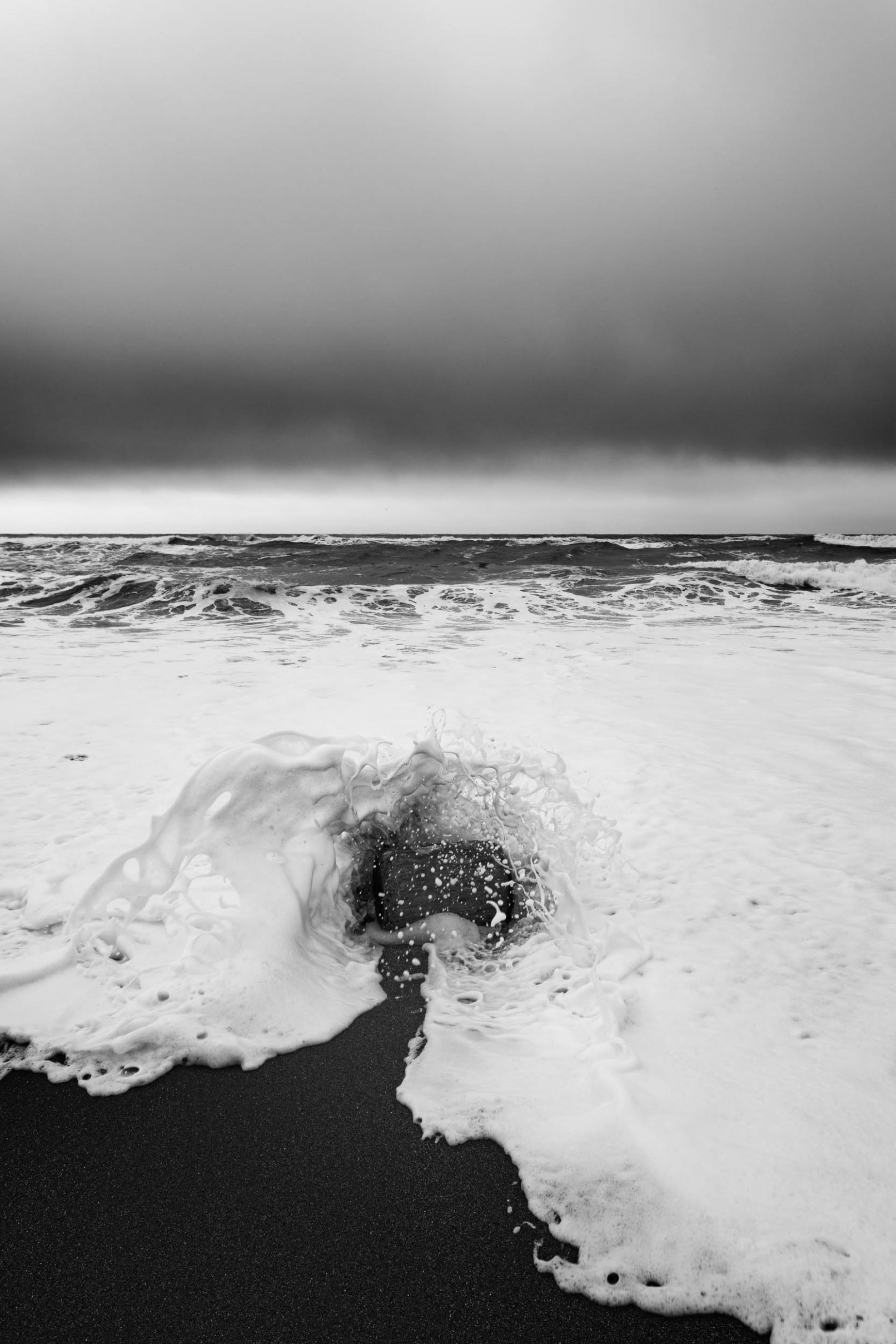 Log on beach with rough waves
