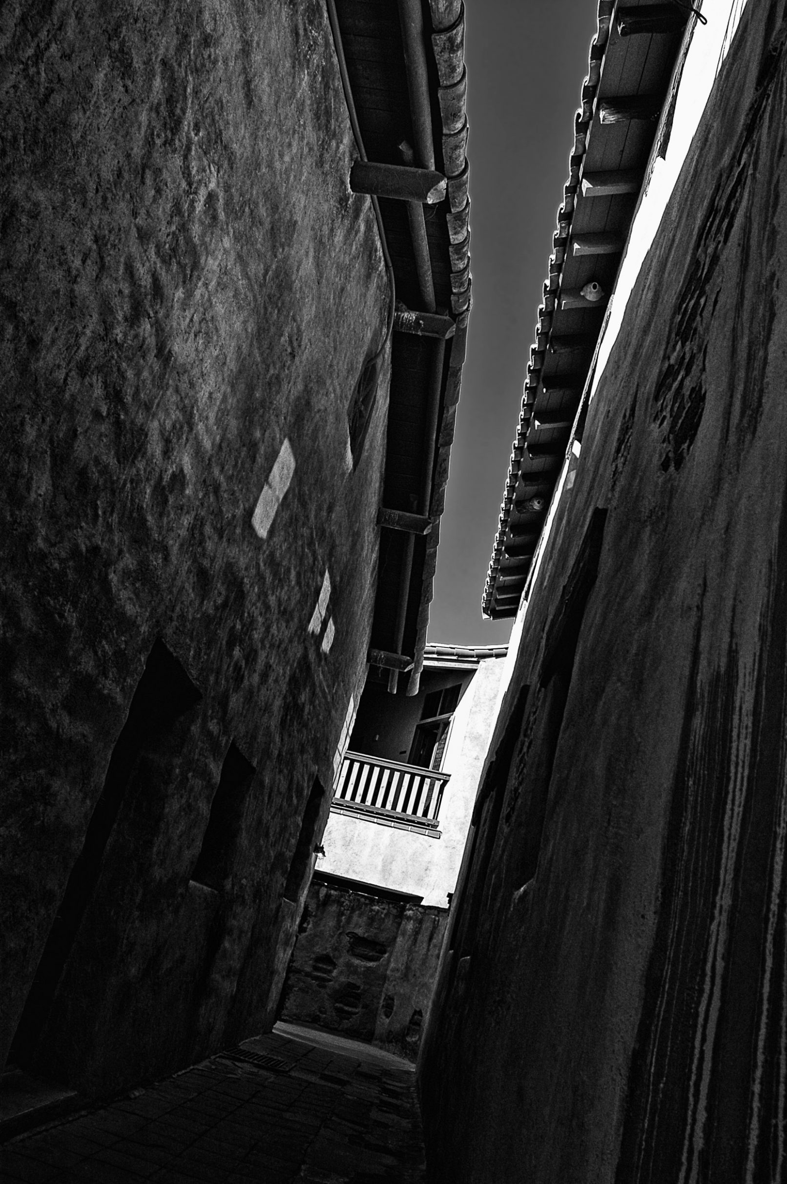 Dark alley between Spanish-styled buildings