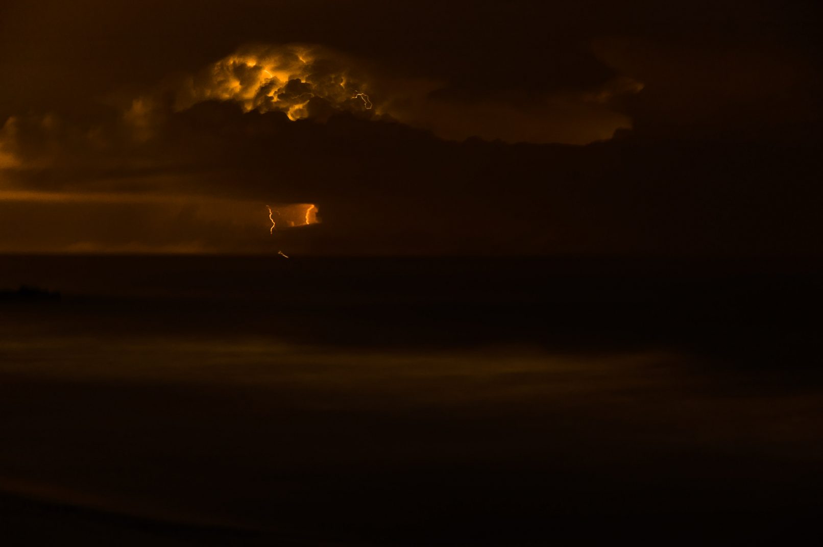 Lighting bolt at night over ocean