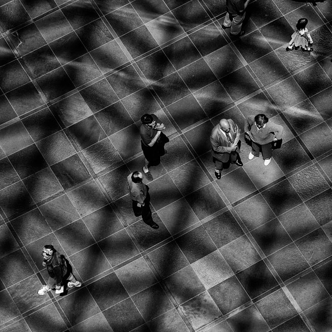 Group of people from above with sun shining on floor through glass roof