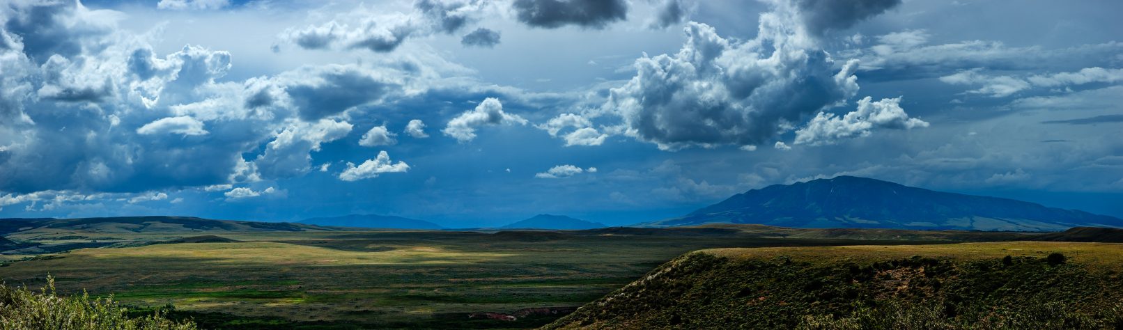 Plains of Wyoming with puffy clouds and distant mountains