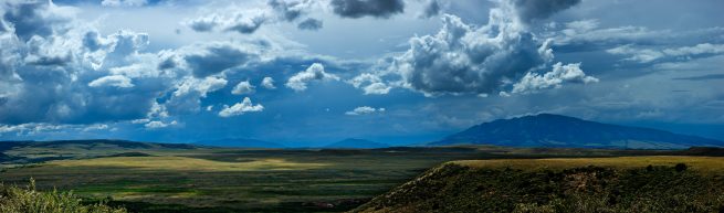 Plains of Wyoming with puffy clouds and distant mountains