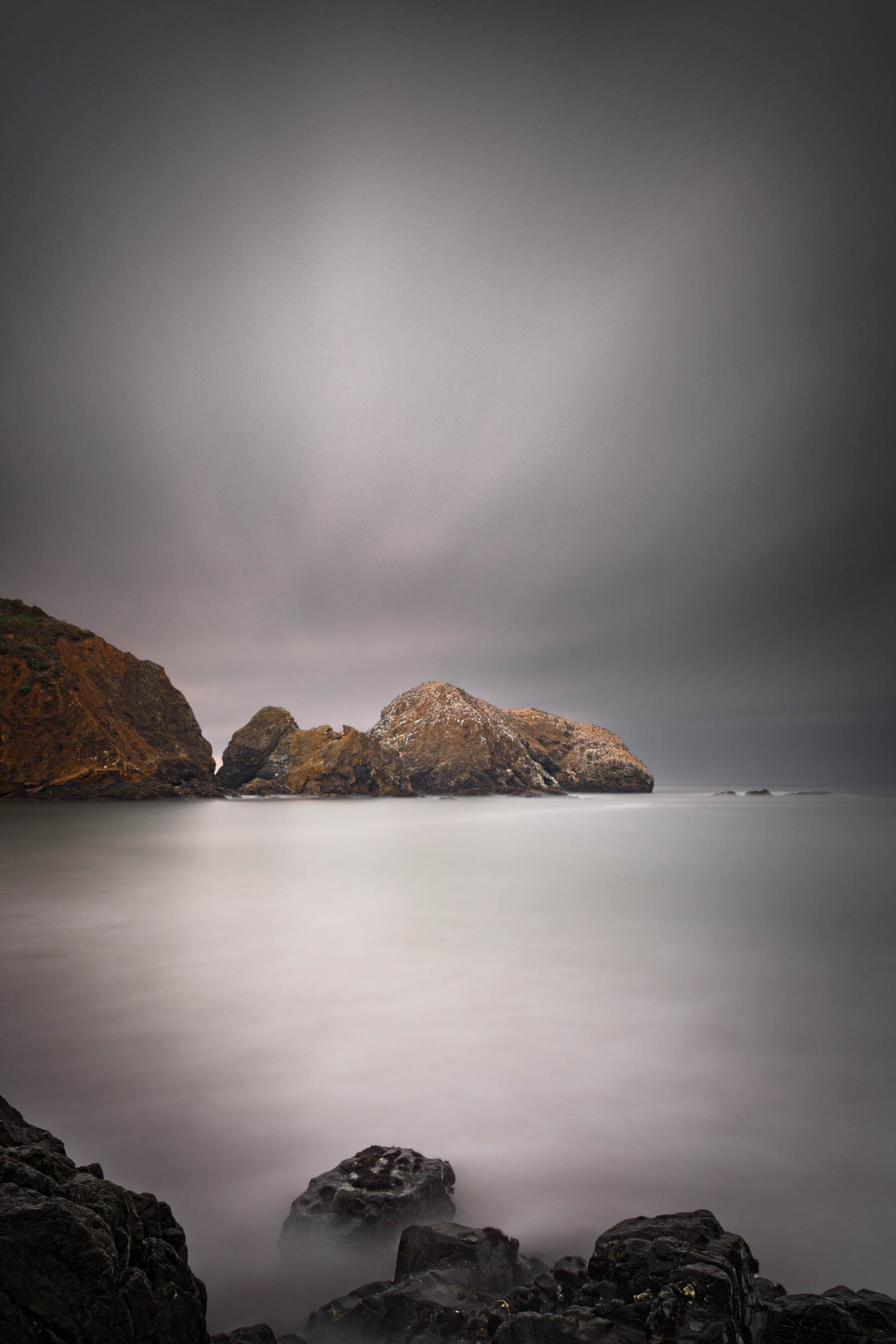 Rocks at Rodeo Beach, California with streaked clouds
