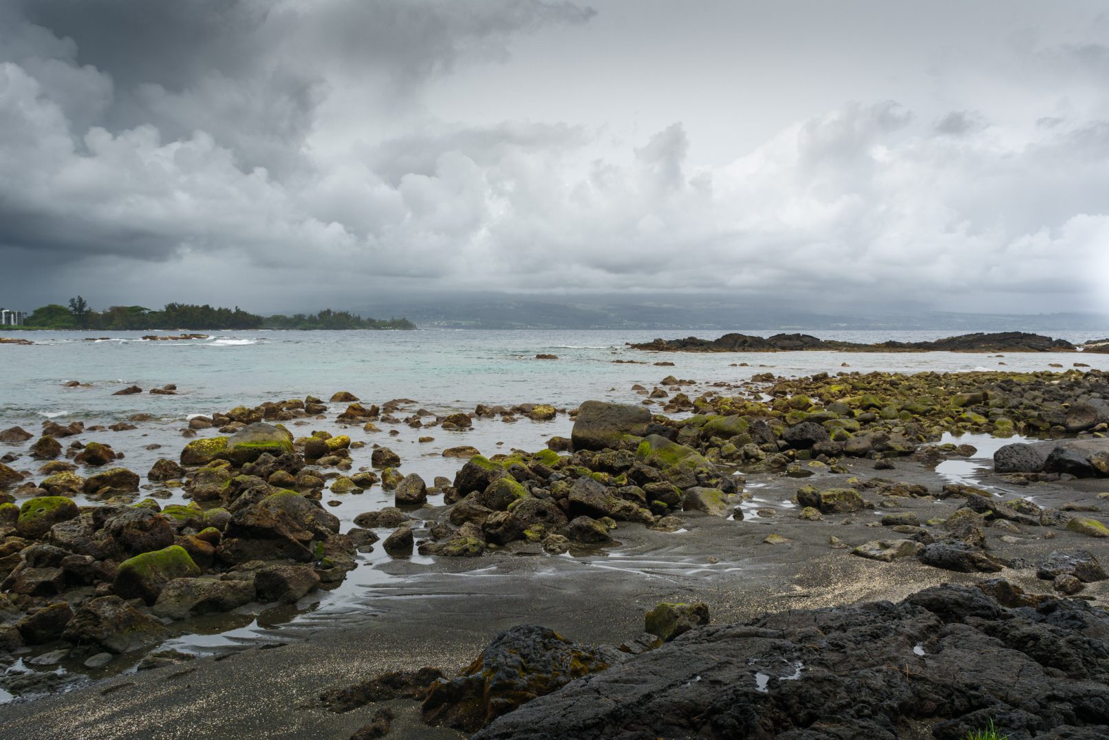 Hawaii rocky beach with moss and stormy sky