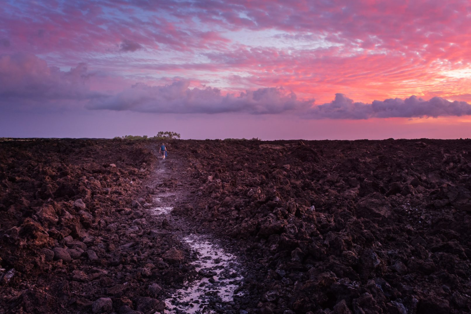 Hawaii, lava rock field with colored clouds and sunset between Mahai'ula Beach and Makalawena Beach