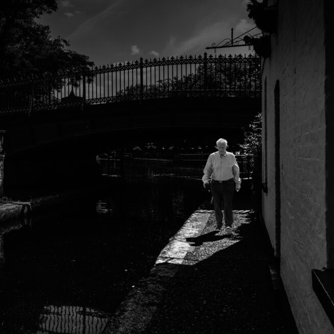 old man walking near canal, London