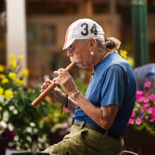 Old man with flute on street